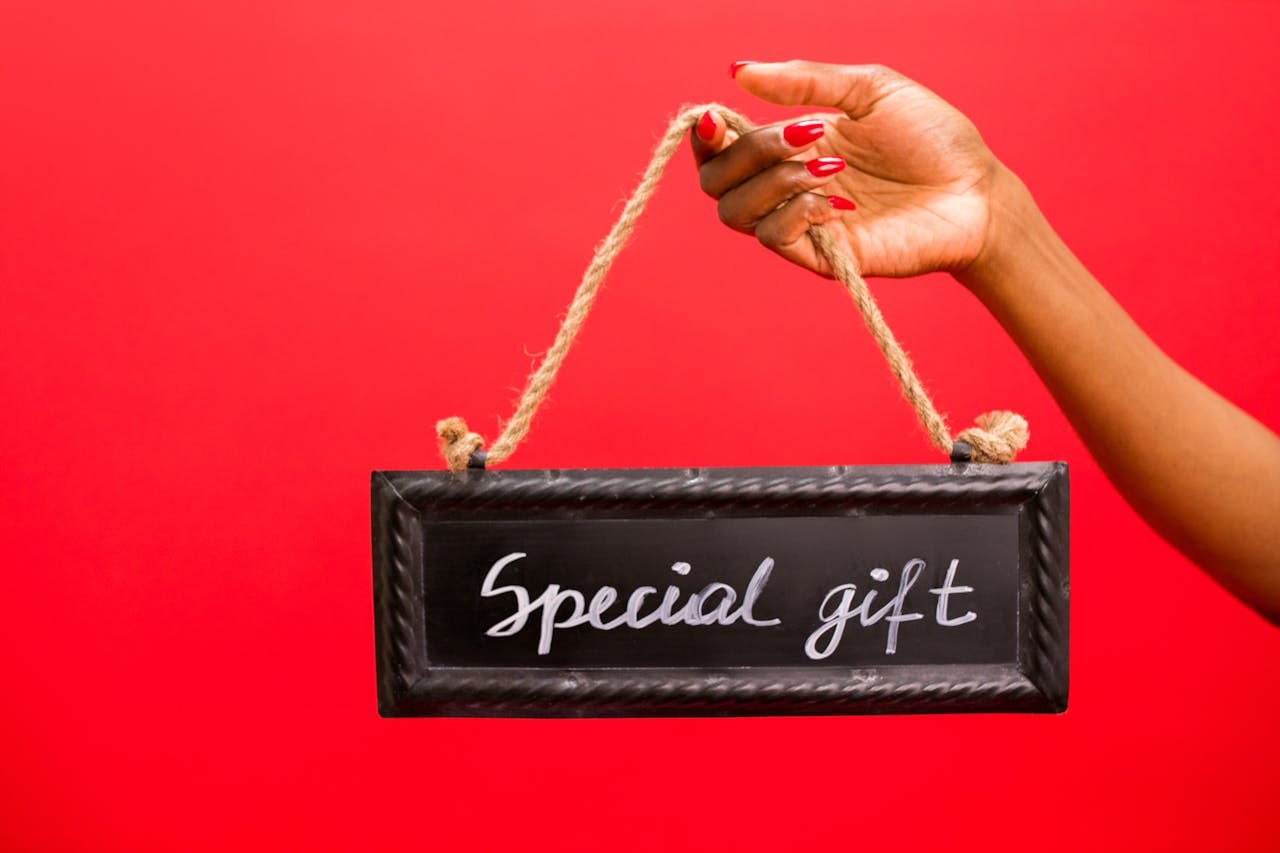 A hand holding a chalkboard sign with 'Special Gift' text against a red background.